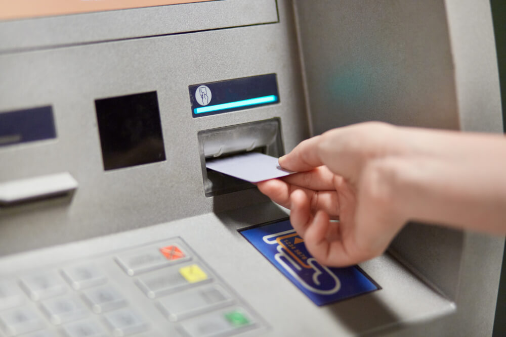 ATM automatába egy női kéz bankkártyát helyez be